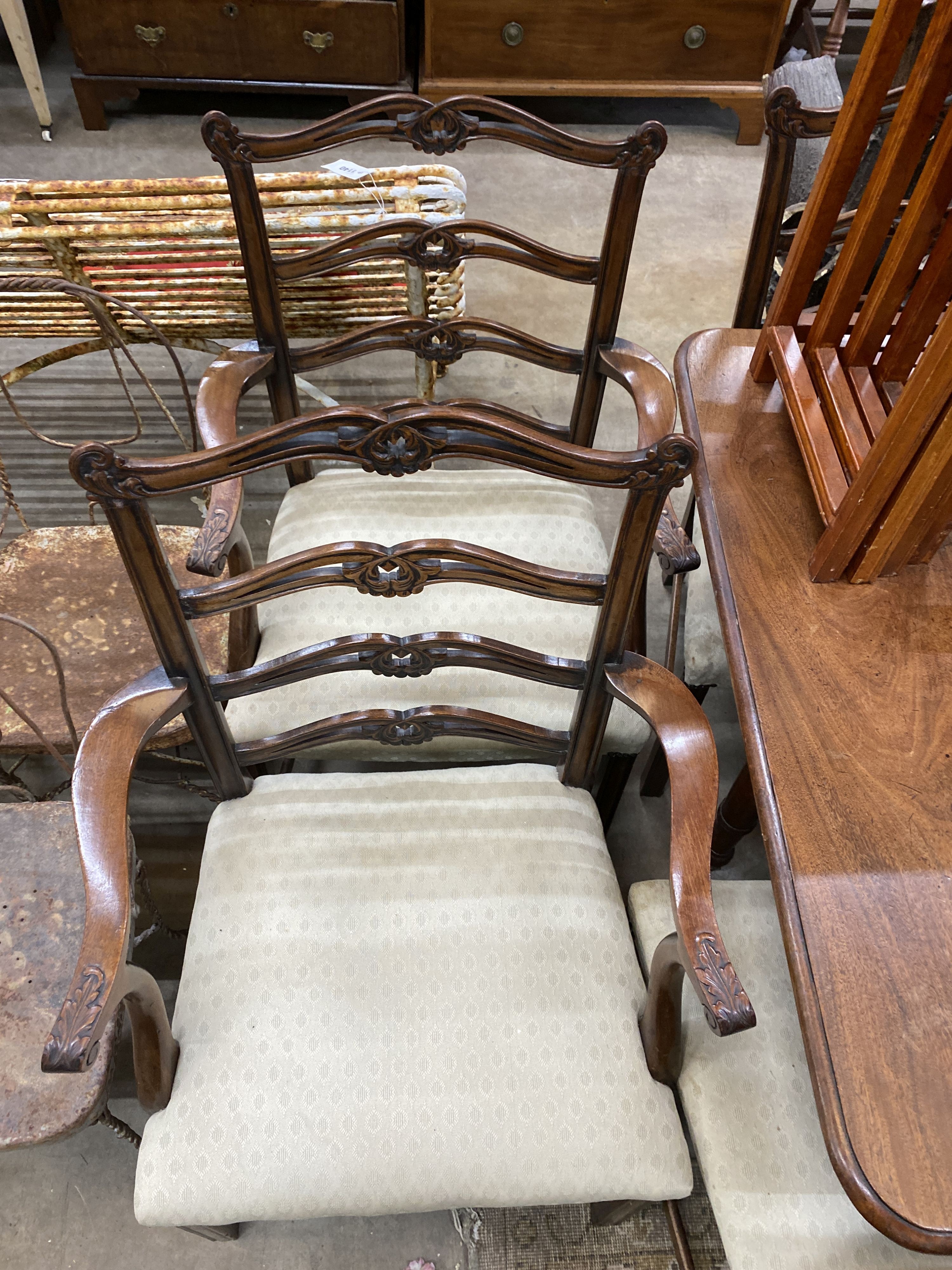 A set of eight Chippendale style mahogany dining chairs with pierced ladder backs, two with arms